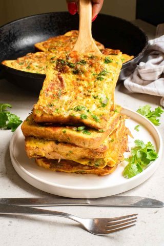 A stack of Bombay Toast on a plate with a wooden spoon.