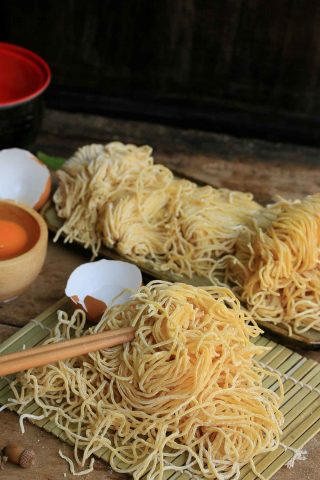 A plate of Swept Hokkien Noodles with chopsticks on it.