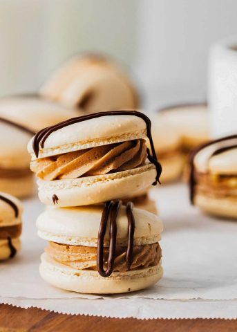 A stack of German chocolate macarons with chocolate drizzle.