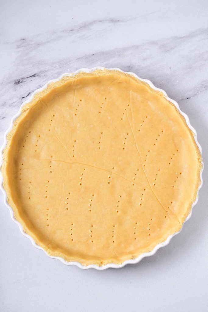 A pie crust is sitting on a white plate.