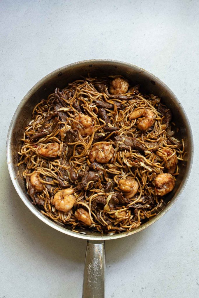 A pan of stir-fried Hokkien noodles with shrimp and beef.