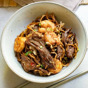 A bowl of stir-fried Hokkien noodles with beef and shrimp.