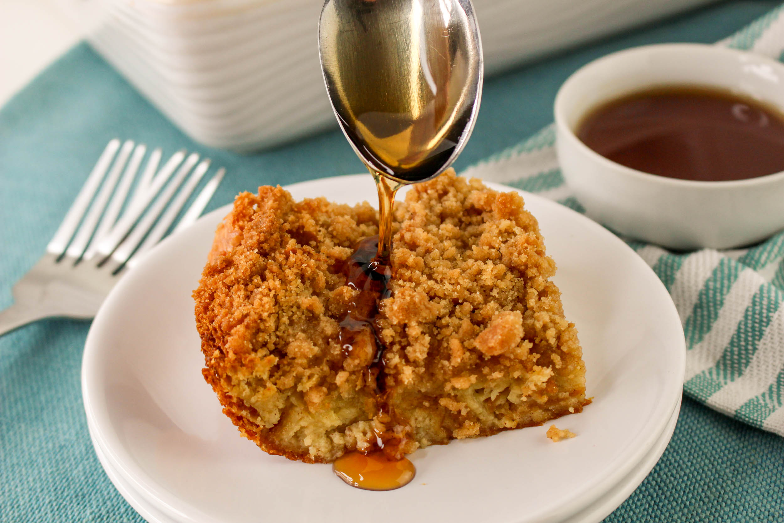 Drizzling syrup onto a crumbly piece of French toast casserole