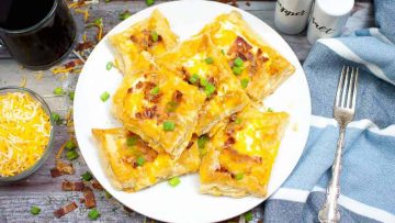 A plate of air fryer breakfast tarts garnished with green onions and cheese.