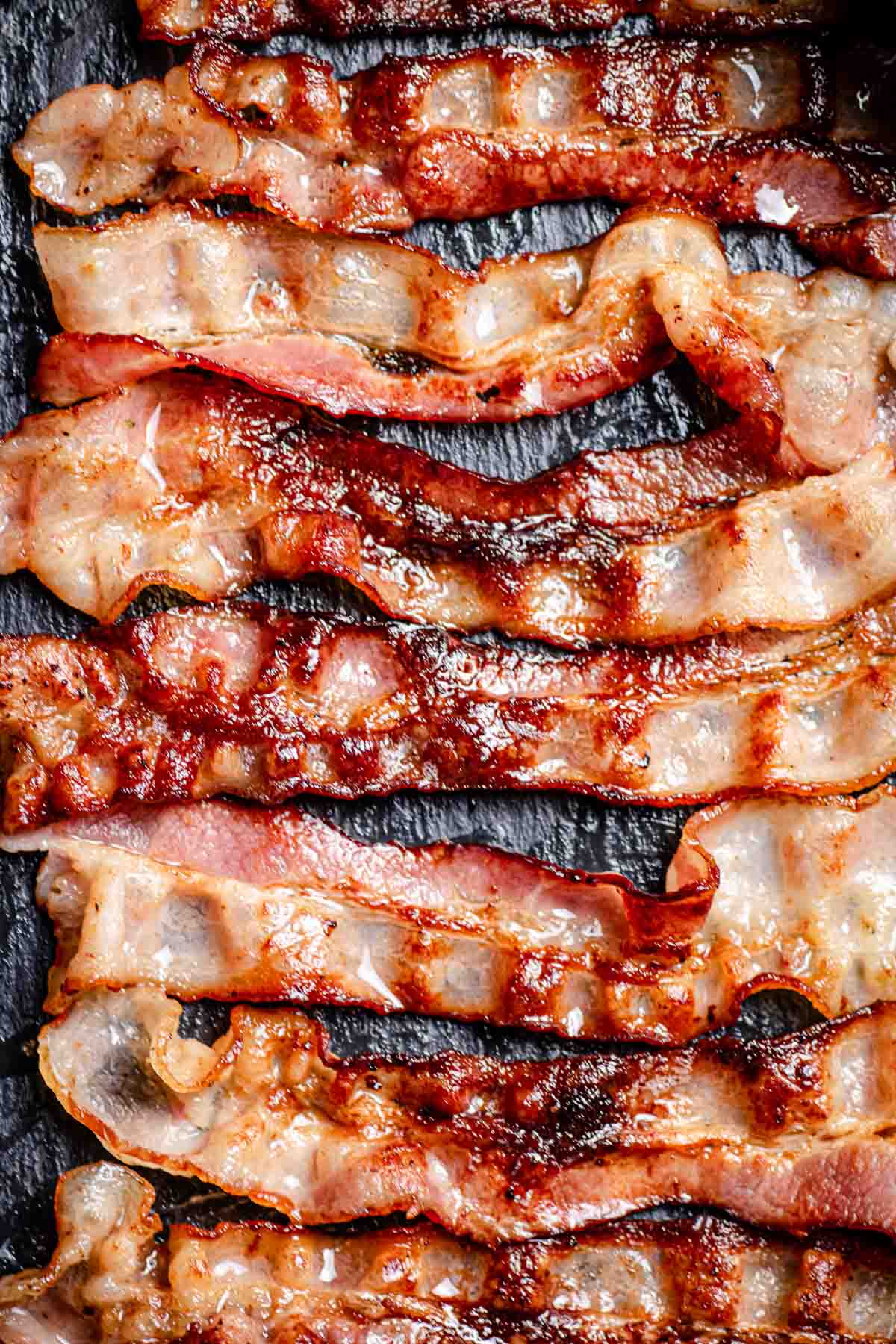 Strips of crispy bacon cooking in an oven.