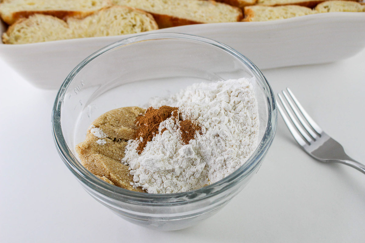 A bowl containing flour and spices with a fork on the side, possibly in preparation for a French Toast Casserole breakfast recipe.