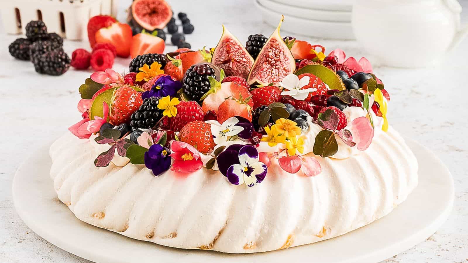 A pavlova topped with berries and figs.